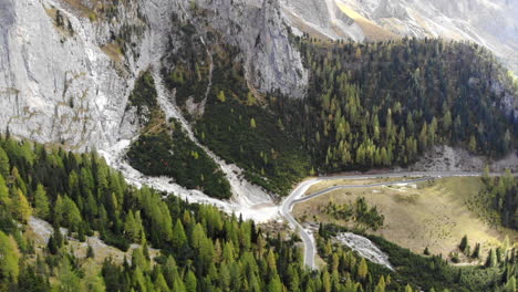 drone che si inclina dagli alberi per rivelare una montagna gigante nelle dolomiti italiane