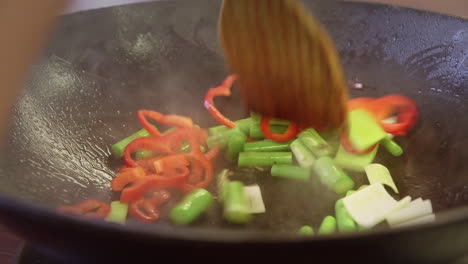 stir-frying vegetables in a wok