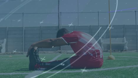 Animation-of-scope-scanning-over-male-football-player-stretching-legs-on-pitch
