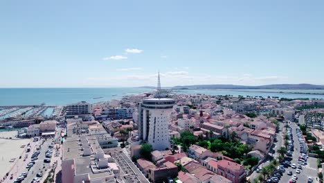 Toma-Aérea-Del-Faro-De-Palavas-En-La-Ciudad-De-Grande-Motte-Con-Hermoso-Puerto-Y-Paisaje-Marino-Azul-En-Verano---Francia,-Europa