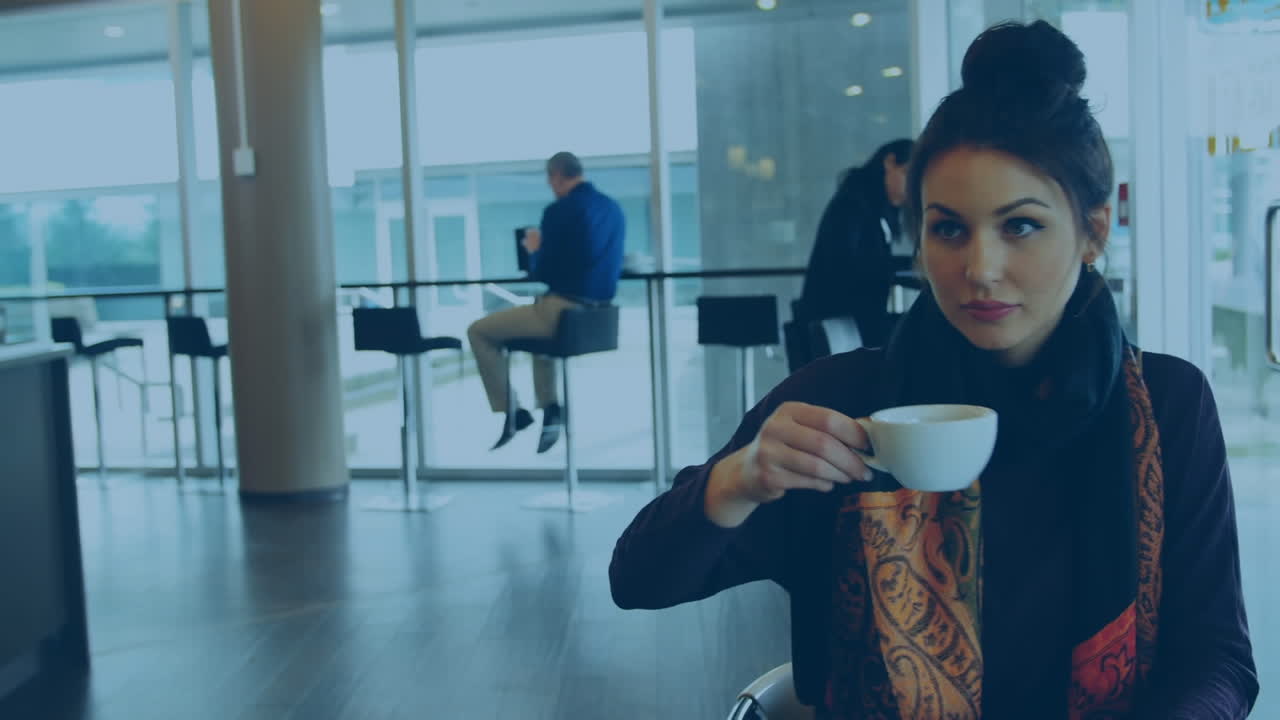 Animação de ícones de polegar para cima sobre mulher caucasiana a beber café e a usar portátil numa cafeteria