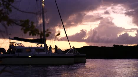 large catamaran coming into shore during a stunning sunset on an island in the caribbean