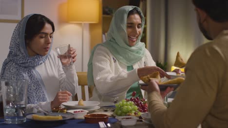 muslim muslim family sitting around table at home eating meal together 1