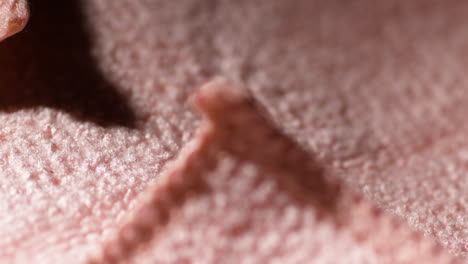 macro shot of a pink handcloth texture with detailed fibers and soft focus