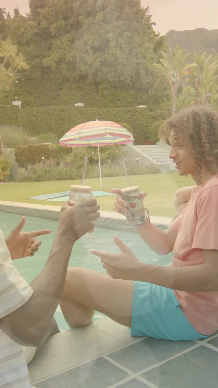 Enjoying drinks by poolside, friends having summer fun