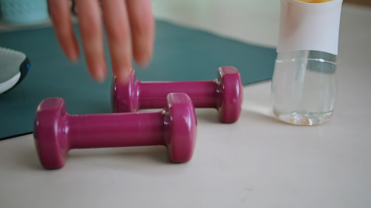 Woman hands taking dumbbells on floor at daily workout closeup. Lady fitness