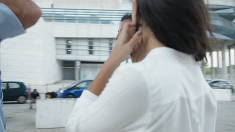 tres empleados parados afuera en un día ventoso y conversando