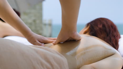 masseuse giving back massage to woman