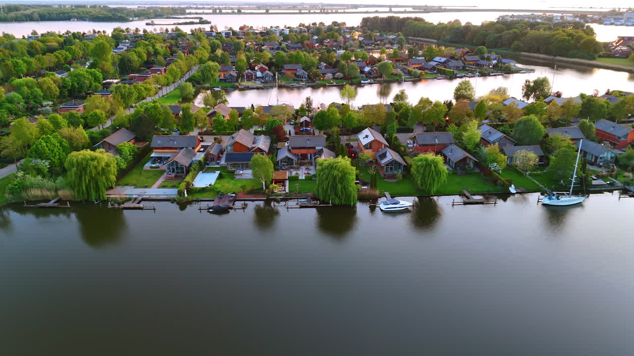 Stunning Dutch waterfront homes. Picturesque homes line the waterside in the Netherlands, surrounded by lush greenery and tranquil reflections at sunset