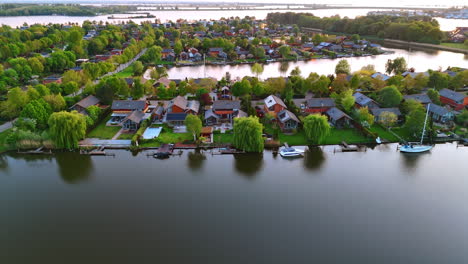 stunning dutch waterfront homes. picturesque homes line the waterside in the netherlands, surrounded by lush greenery and tranquil reflections at sunset