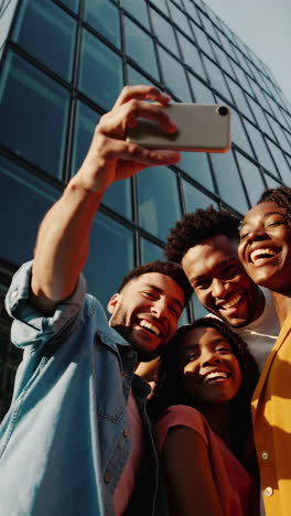diverse group of happy friends taking a selfie outdoors