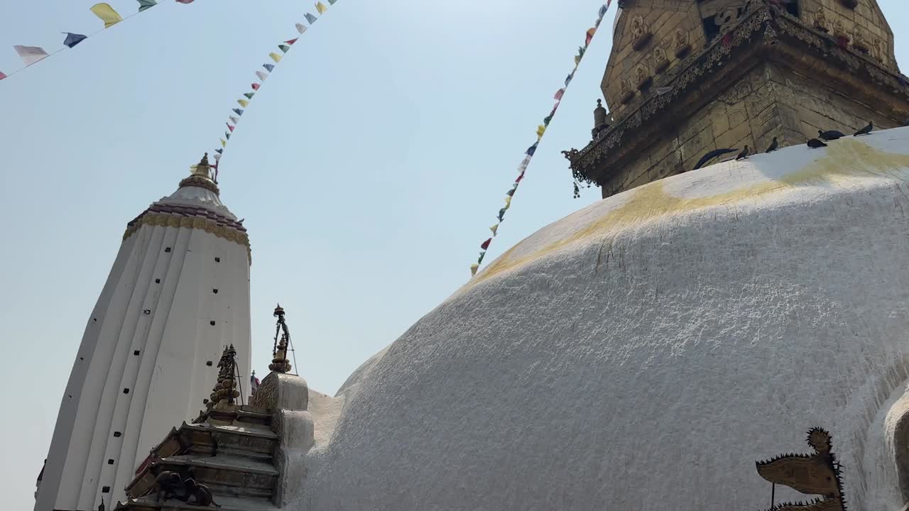 Stable shot of Buddhist temple with prayer flags fluttering in Kathmandu, Nepal.