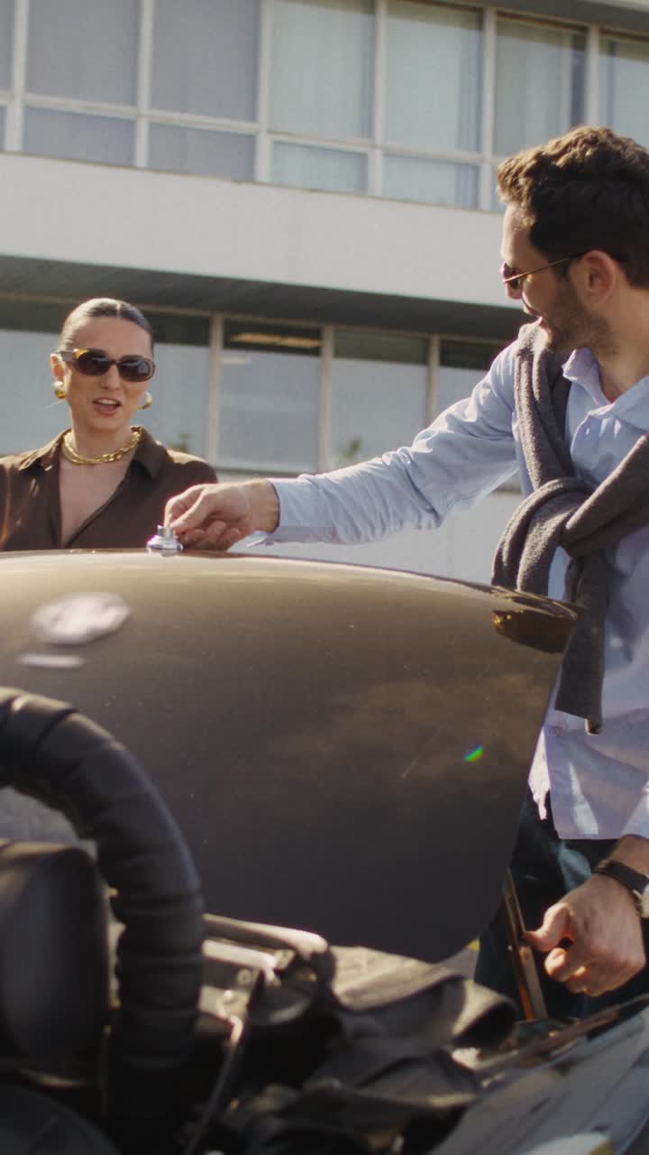 Couple Checking a Car in a City Parking Lot