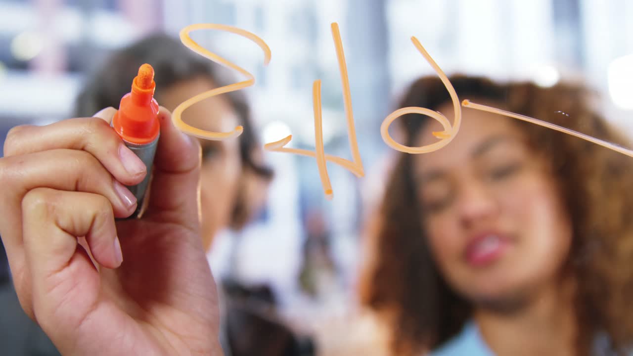 colegas de negocios hablando mientras escriben en una ventana de vidrio