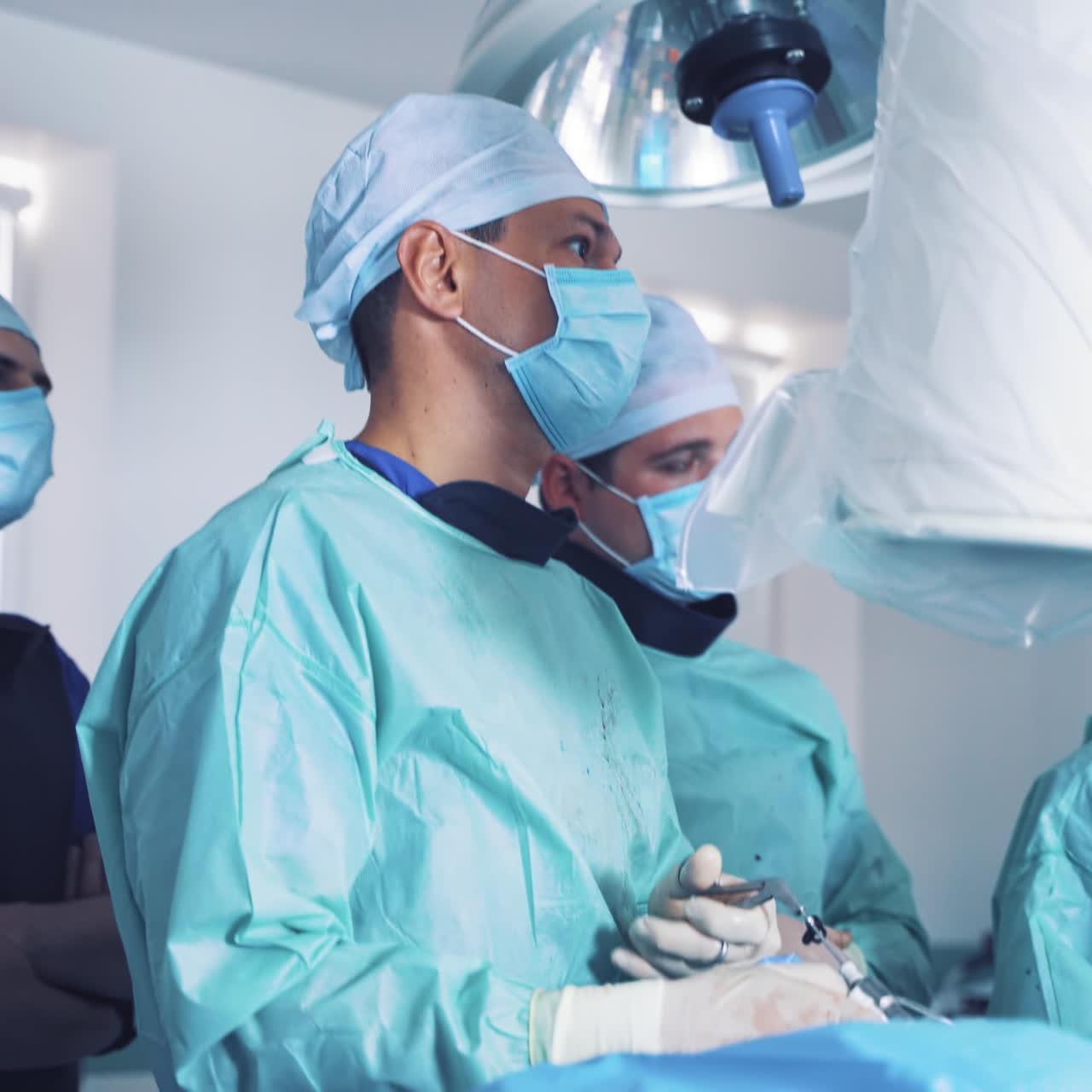 Professional neurosurgeon performs the operation. Teamwork of specialists in the operating room. Surgeon uses special medical instruments for treatment.