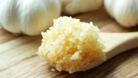 Close up of minced garlic on a wooden spoon ,