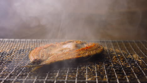 Räuchern-Von-Ide-Fischsteak-Mit-Heißem-Dampf-Auf-Einem-Gitter,-Das-Auf-Chips-Liegt