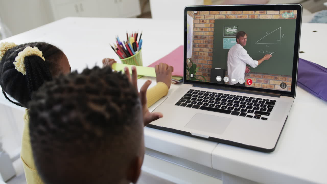 composición de una escolar afroamericana y un escolar en una computadora portátil aprendiendo en línea con un maestro