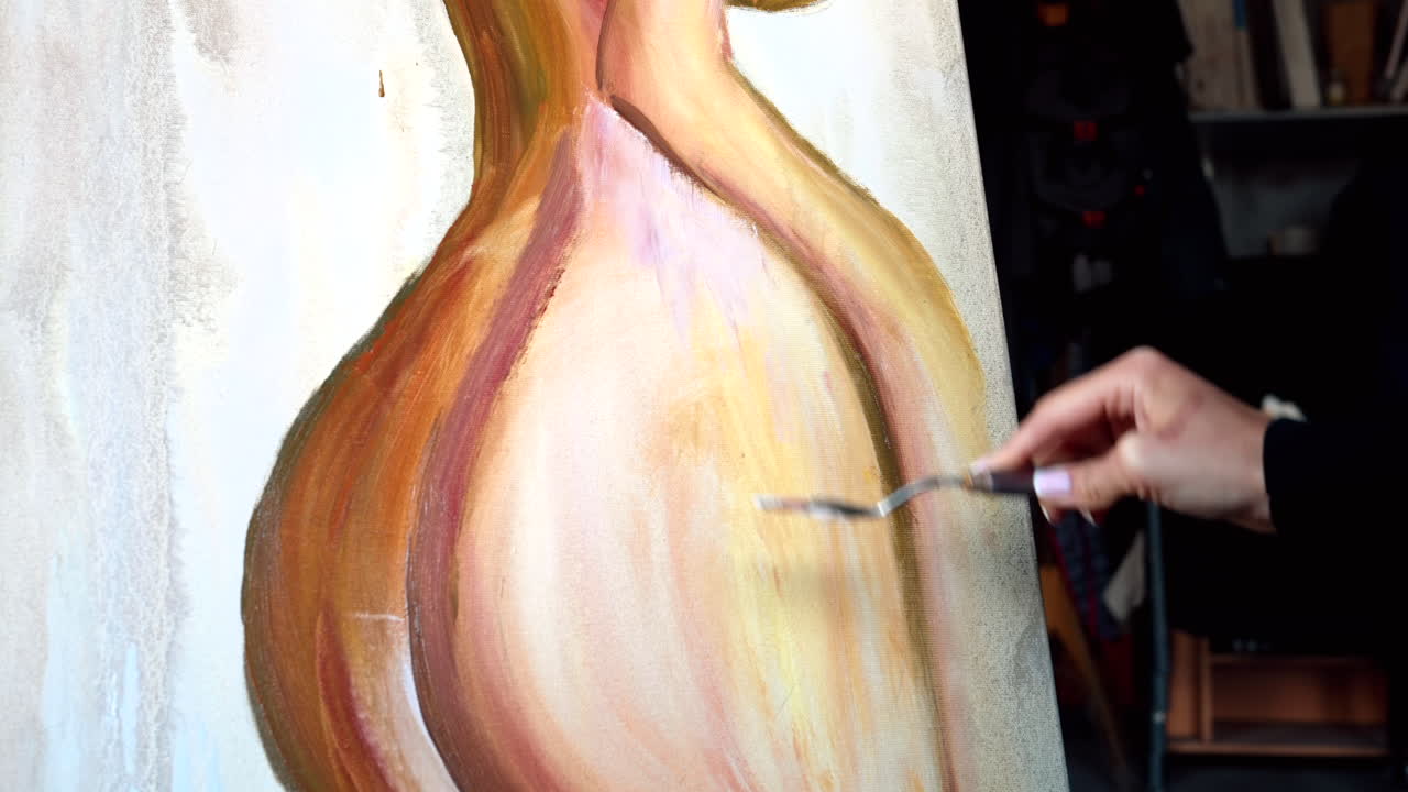 Primo piano di una donna che dipinge su un’area di lavoro durante un workshop in una galleria d’arte