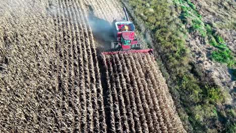 aerial-tracking-shot-of-combine-harvester-gathering-cereal-crops-field