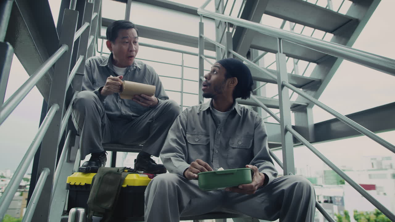 Foreman and Builder Eating Lunch while Resting on Stairs