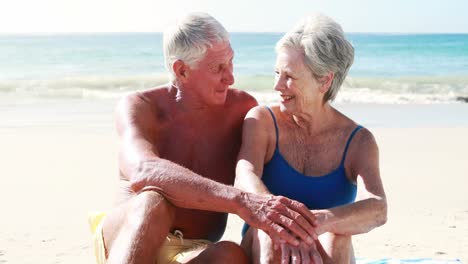 Retired-old-couple-sitting-on-towel