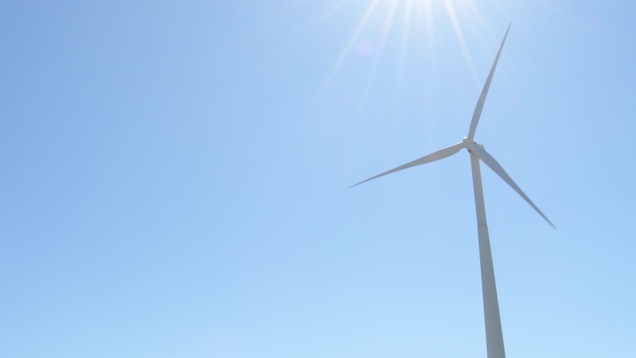 energía de la turbina eólica moviendo las palas un día soleado - bucle