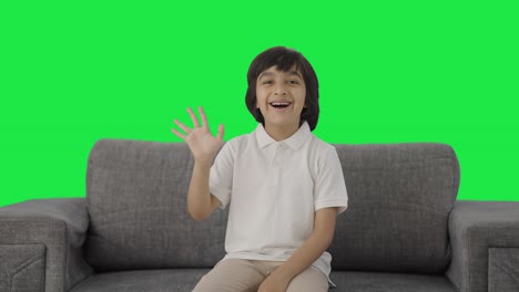 happy indian boy saying hello to the camera green screen