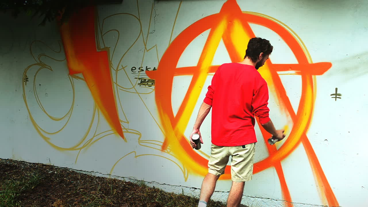 L'artista realizza graffiti su una recinzione. Disegno astratto