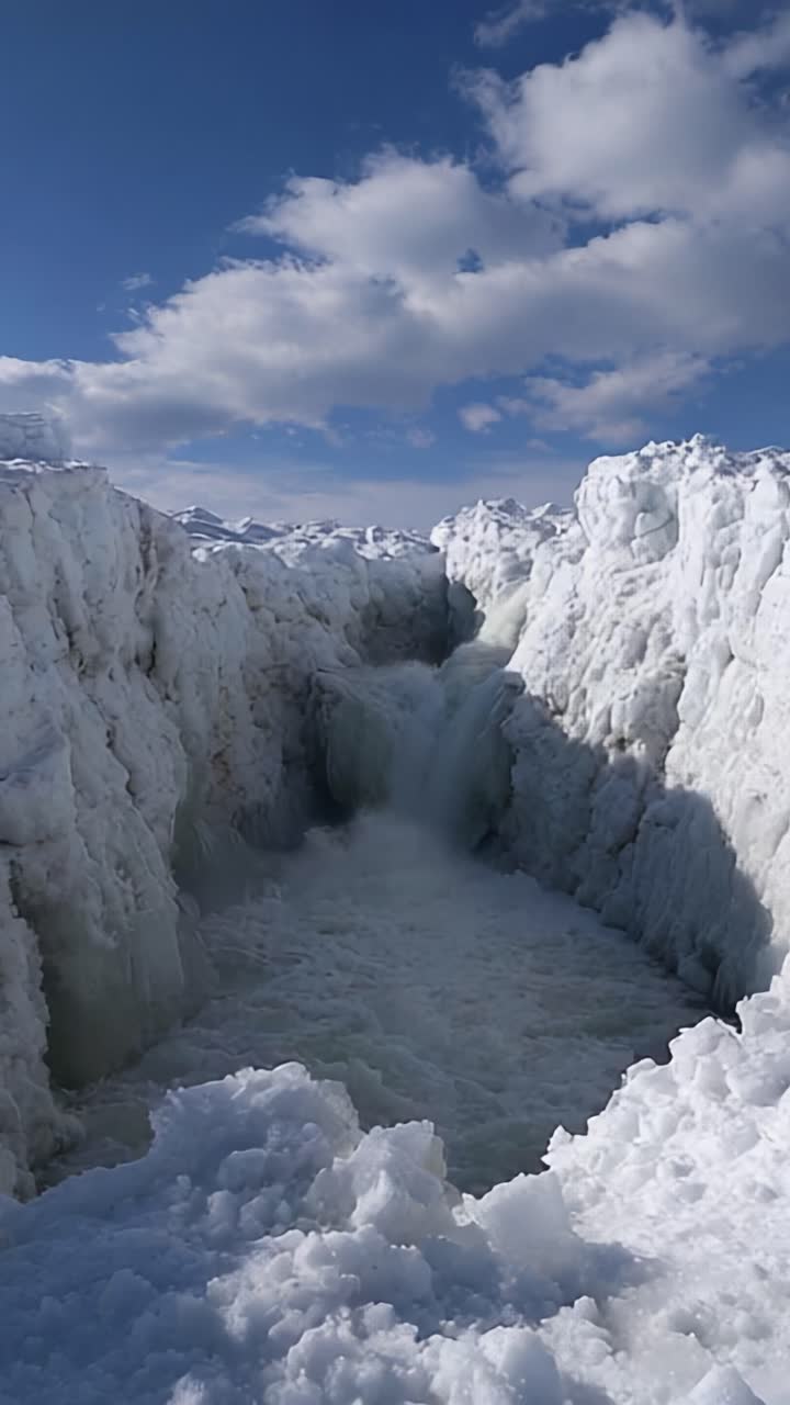 A Stunning Glimpse of Nature's Winter Wonderland Featuring Ice-Capped Cliffs, Cascading Waterfalls, and Dramatic Clouds Underneath a Bright Blue Sky