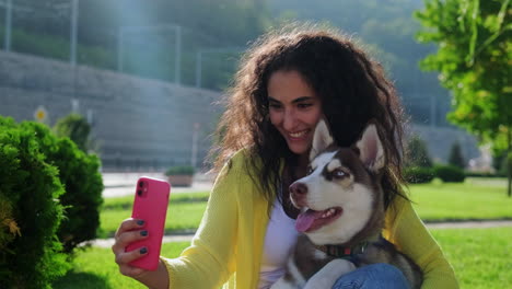 mujer tomando una selfie con su cachorro husky en un parque