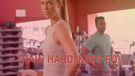 animation of train hard keep fit text over diverse man and woman exercising in gym