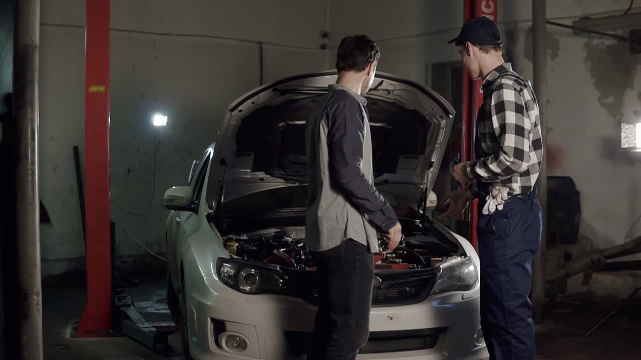 남성 고객이 자동차 열 ⁇ 를 돌려받고 자동차 서비스 대표와 손을 흔들고 있습니다. 자동차 수리, 유지보수, 사람 개념.