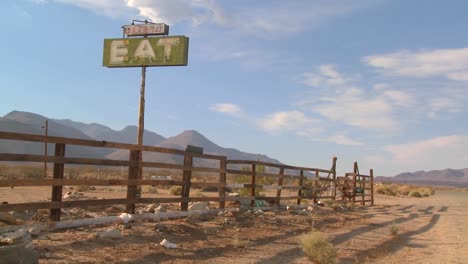 pan shot across and abandoned diner with a sign saying eat