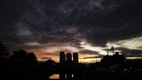 Cielo-Oscuro-Al-Atardecer-Con-Silueta-Urbana-En-Primer-Plano