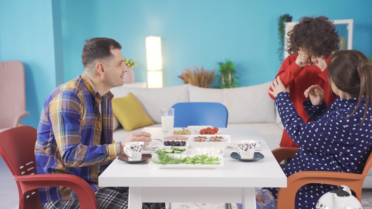 부모가 건강한 아침 식사를 하고 있을 때, 새로 깨어난 아이는 잠들어 아침 식사 테이블에 온다.