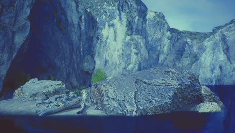 natural rock formations near a calm lake surrounded by rugged cliffs