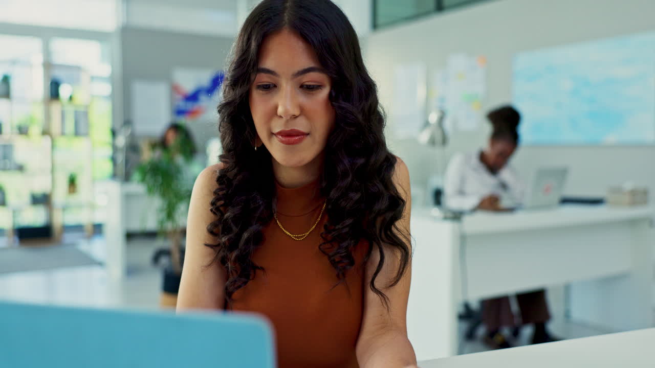 mujer concentrándose en su computadora portátil en una oficina moderna