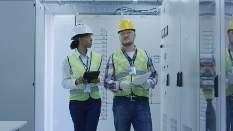 electrical engineers inspecting equipment in a control room