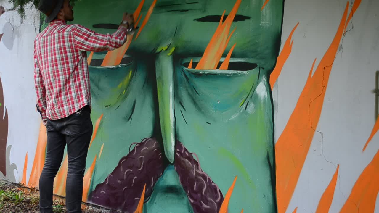 L'artista disegna graffiti su una recinzione, disegno di Kozak.