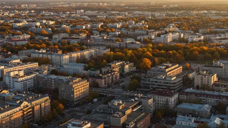 aerial view of urban landscape captured at sunset, showcasing vibrant autumn foliage and diverse architectural styles in a thriving city environment