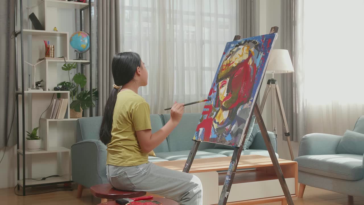 Side View Of An Asian Artist Girl Holding Paintbrush Mixed Colour And Thinking Before Painting A Girl'S Hair On The Canvas