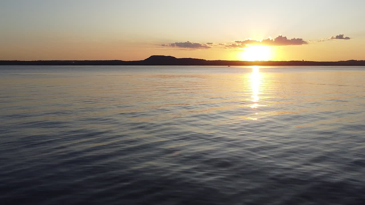 toma aérea de una mujer de pie en el muelle durante la puesta de sol en san bernardino paraguay en una hermosa tarde de verano