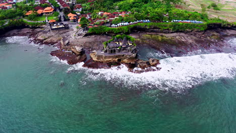 ancient hindu tanah lot temple on rock formation in sea waves in bali