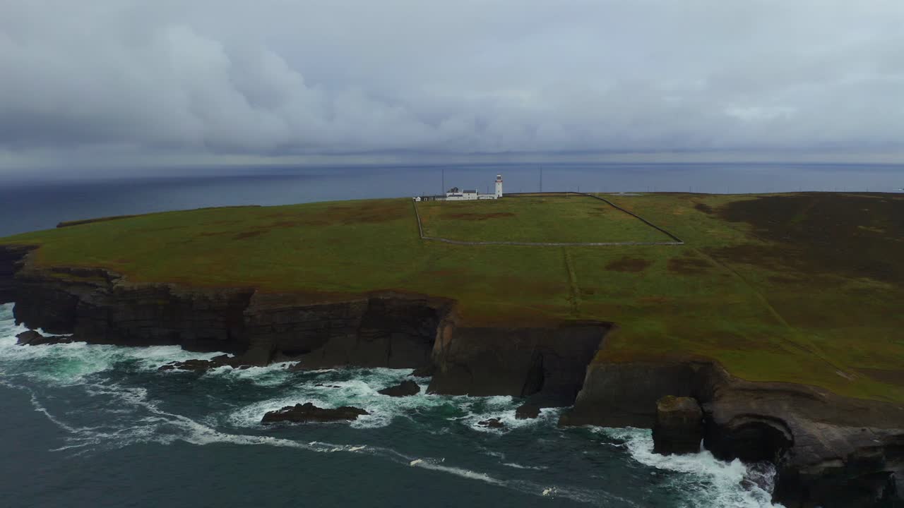 la panorámica aérea captura una amplia vista de los acantilados de la cabeza del bucle y el faro con las olas que se estrellan