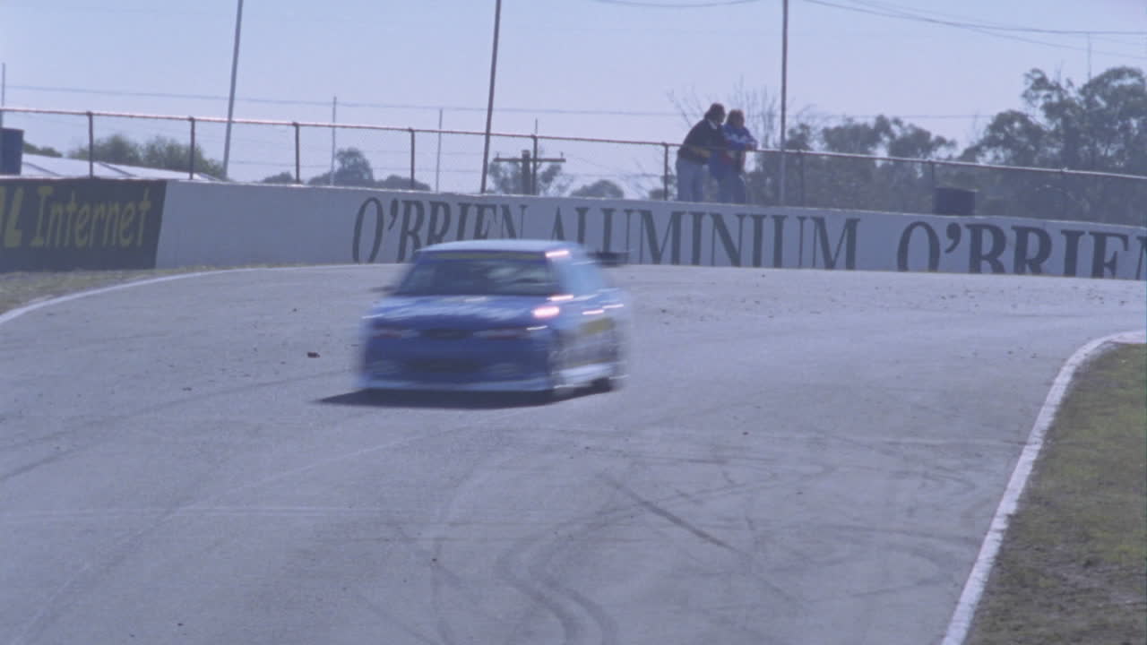 경주용 자동차가 서킷 트랙을 달리다