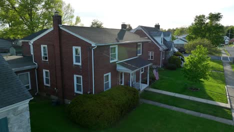 an aerial establishing approach shot of a beautiful colonial style home in an american city