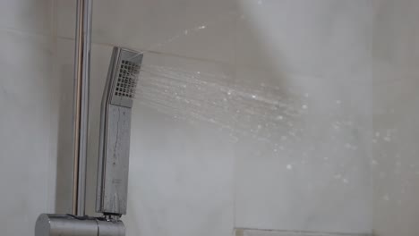 water flowing from a shower head in bathroom