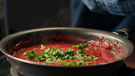 cooking tomato sauce with basil