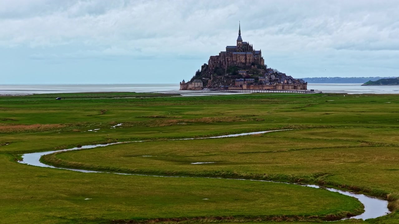 Mont Saint-Michel står prominent omgivet af store tidevandsflader. Ideel til rejsedokumentarer eller kulturhistoriske indslag